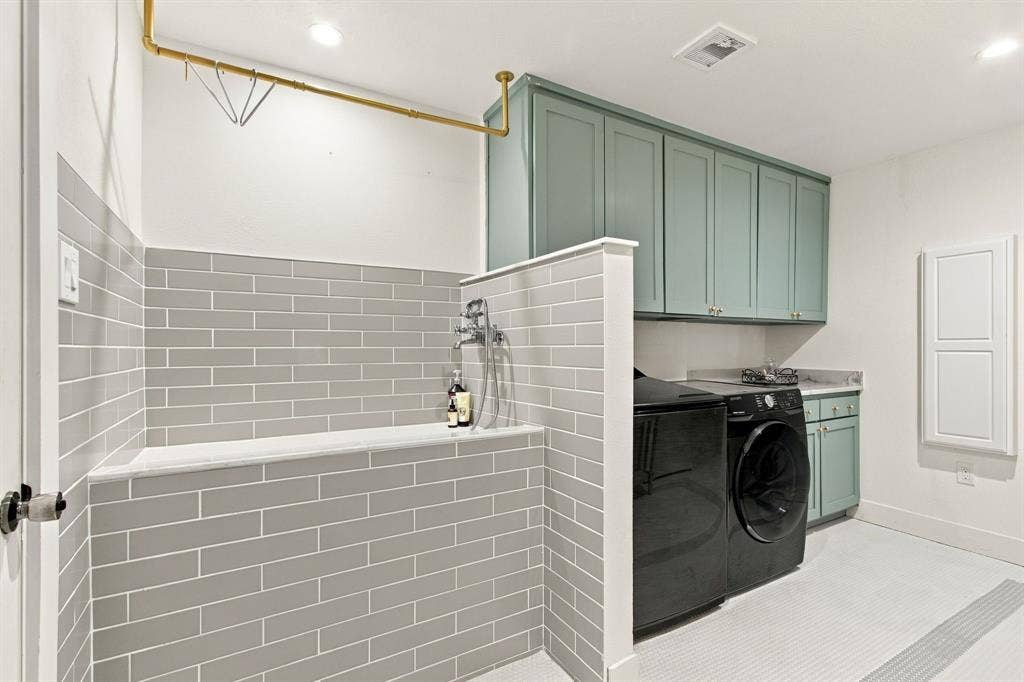 46 Crown Place, Richardson, TX 75080 Utility room featuring a tiled dog washing station with an overhead drying rack, custom cabinetry, a built-in sink, and tile flooring