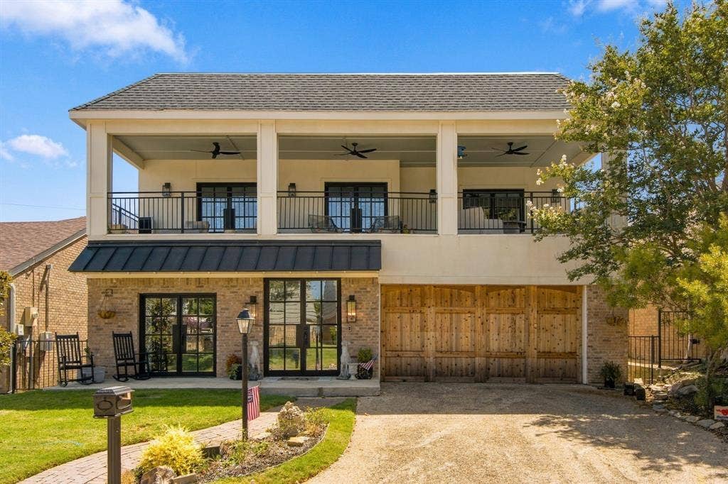 46 Crown Place, Richardson, TX 75080 Brick exterior with a second-story covered balcony featuring black railings and ceiling fans