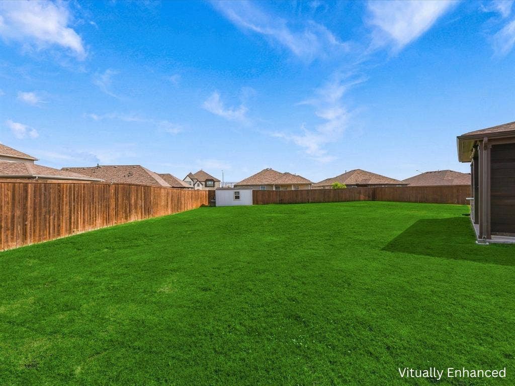 Oversized backyard showing back patio entertaining area and storage building.