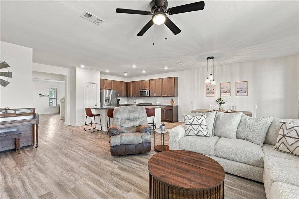 Large open area with dining room, living room, and kitchen with oversized island which provides a lot of additional seating