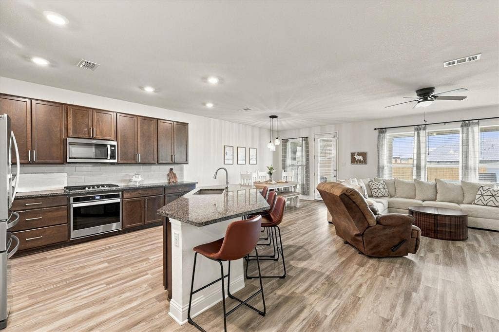 Large open area with dining room, living room, and kitchen with oversized island which provides a lot of additional seating