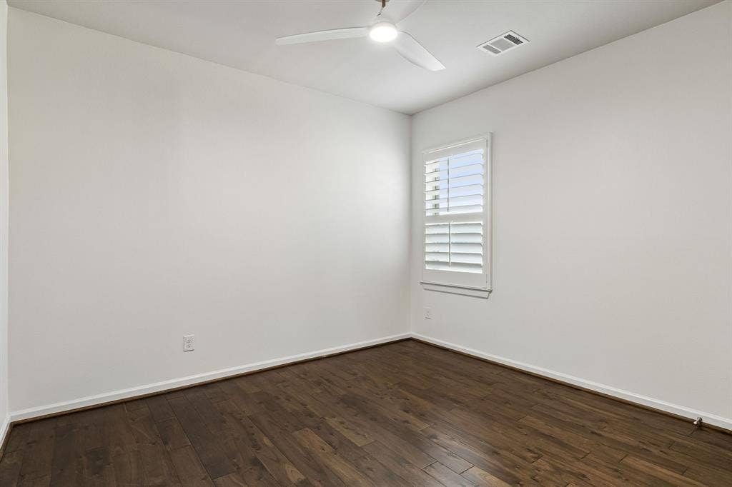 2221 Tremont Boulevard, McKinney, TX 75071 Wood-finish flooring, white walls, and a window with white plantation shutters