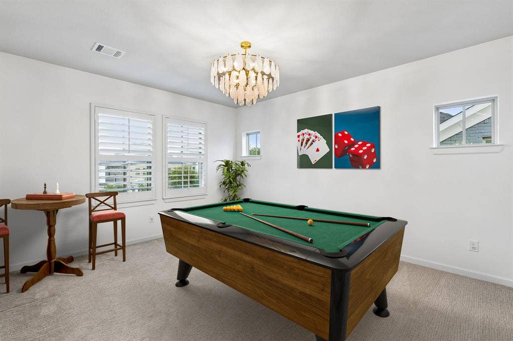 2221 Tremont Boulevard, McKinney, TX 75071 Carpeted room featuring a pool table, multiple windows with white plantation shutters, and a decorative chandelier
