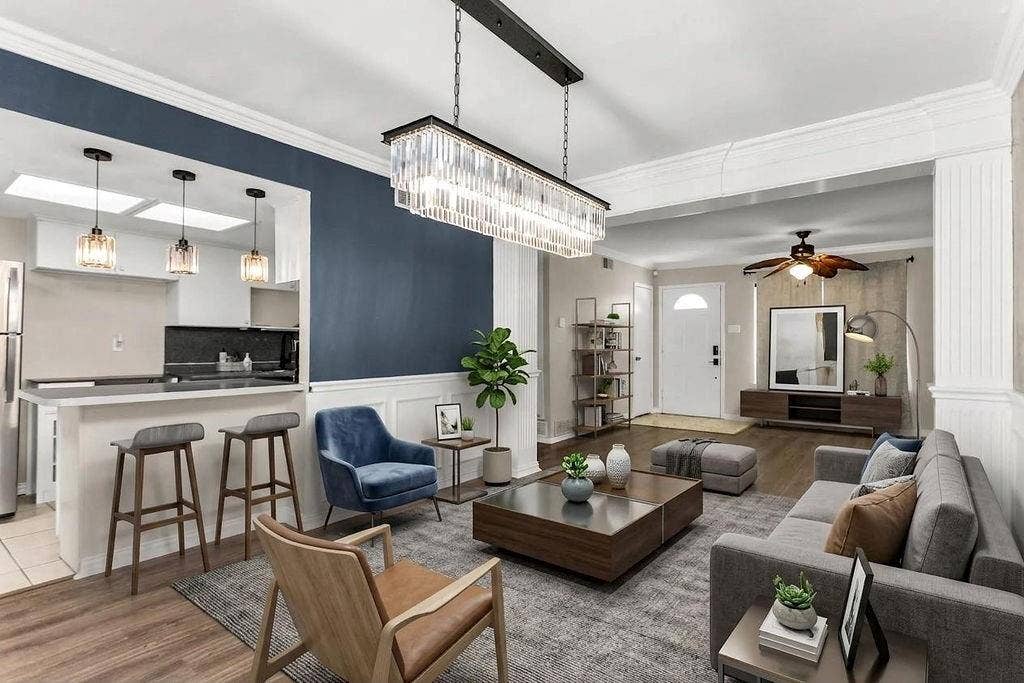 2914 Harvard Street N, Irving, TX 75062 Open-concept living area with wood-finish flooring, a contemporary linear chandelier, and a breakfast bar with pendant lighting