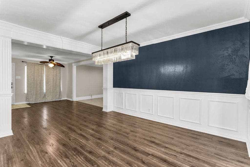 2914 Harvard Street N, Irving, TX 75062 Wood-finish flooring, wainscoting, crown molding, and a crystal chandelier