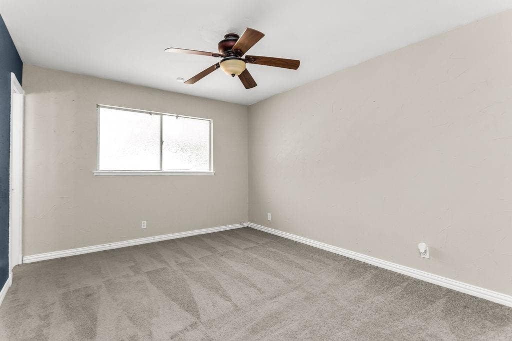 2914 Harvard Street N, Irving, TX 75062 Carpeted room with a ceiling fan, light-toned walls, and a multi-pane window