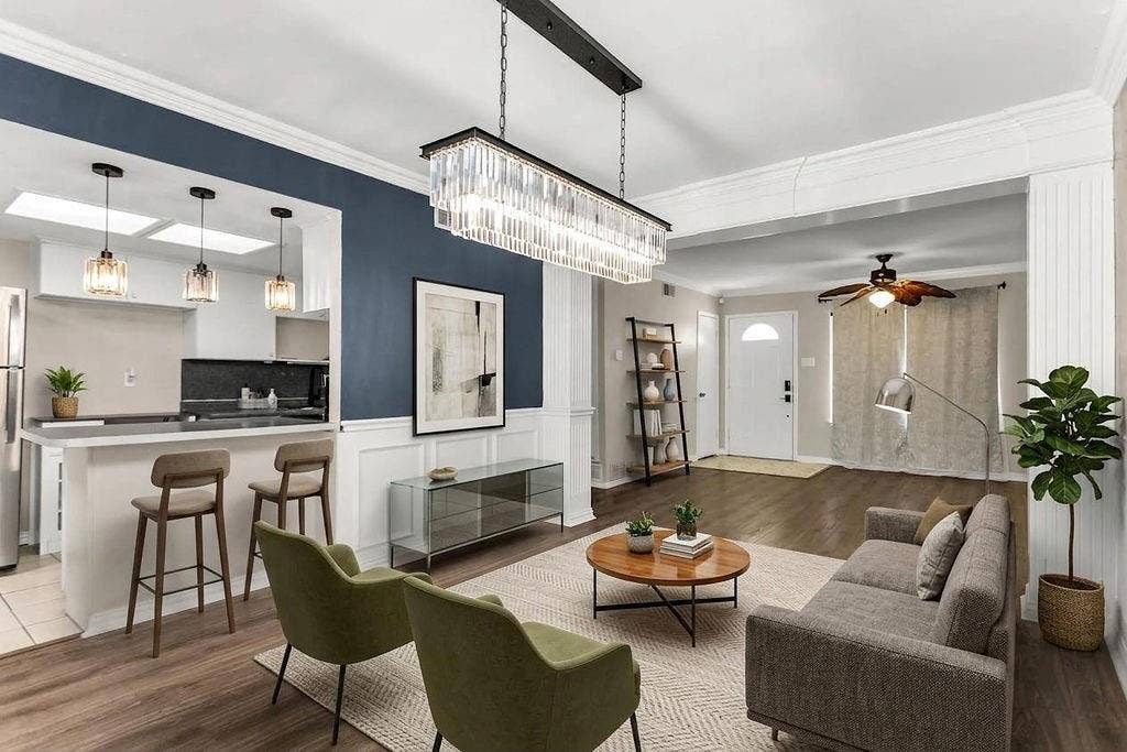 2914 Harvard Street N, Irving, TX 75062 Open-concept living space featuring wood-finish flooring, a contemporary linear chandelier, and a kitchen pass-through with pendant lighting
