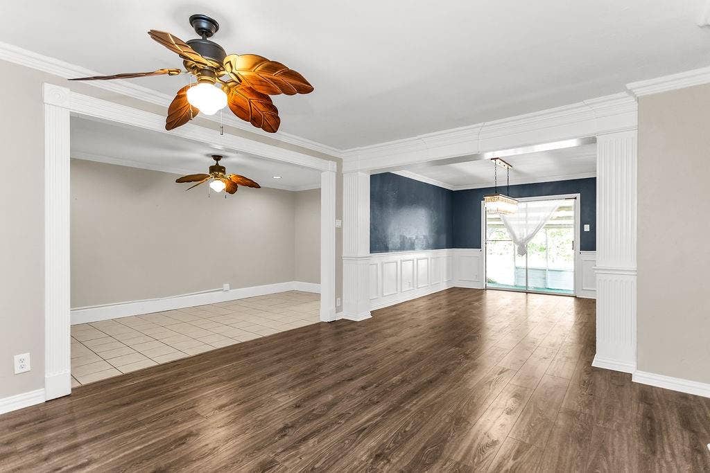 2914 Harvard Street N, Irving, TX 75062 Wood-finish flooring, white decorative wainscoting, sliding glass doors, and a ceiling fan with light fixture