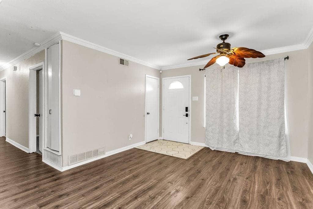 2914 Harvard Street N, Irving, TX 75062 Wood-finish flooring, crown molding, and a ceiling fan with integrated lighting