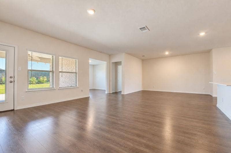 339 Exploration Way, Fate, TX 75189 Spacious room featuring wood-finish flooring, recessed lighting, multiple windows, and a built-in breakfast bar