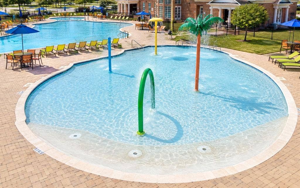 339 Exploration Way, Fate, TX 75189 Large swimming pool with a connected splash pad area featuring multiple water spray elements