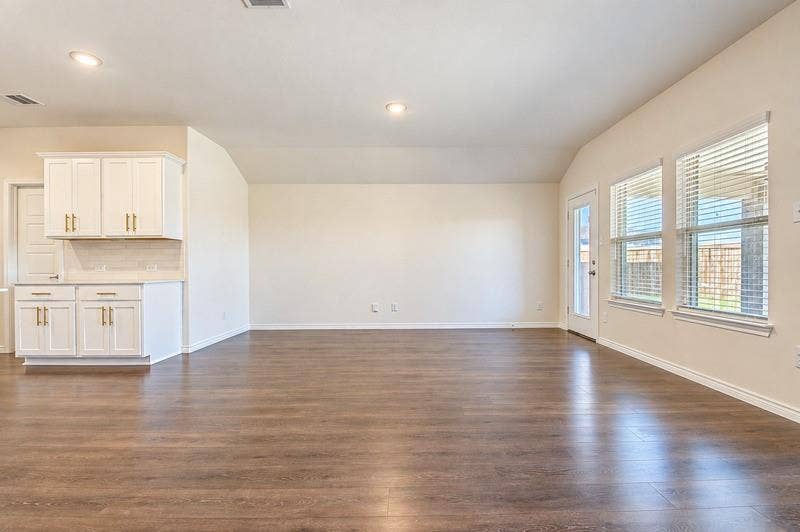 339 Exploration Way, Fate, TX 75189 Spacious interior with wood-finish flooring, white cabinetry with gold-tone hardware, and a glass-paned door