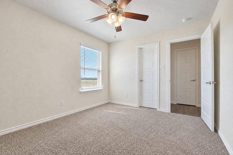 339 Exploration Way, Fate, TX 75189 Plush carpet flooring, ceiling fan with light fixture, window with blinds, and white paneled doors