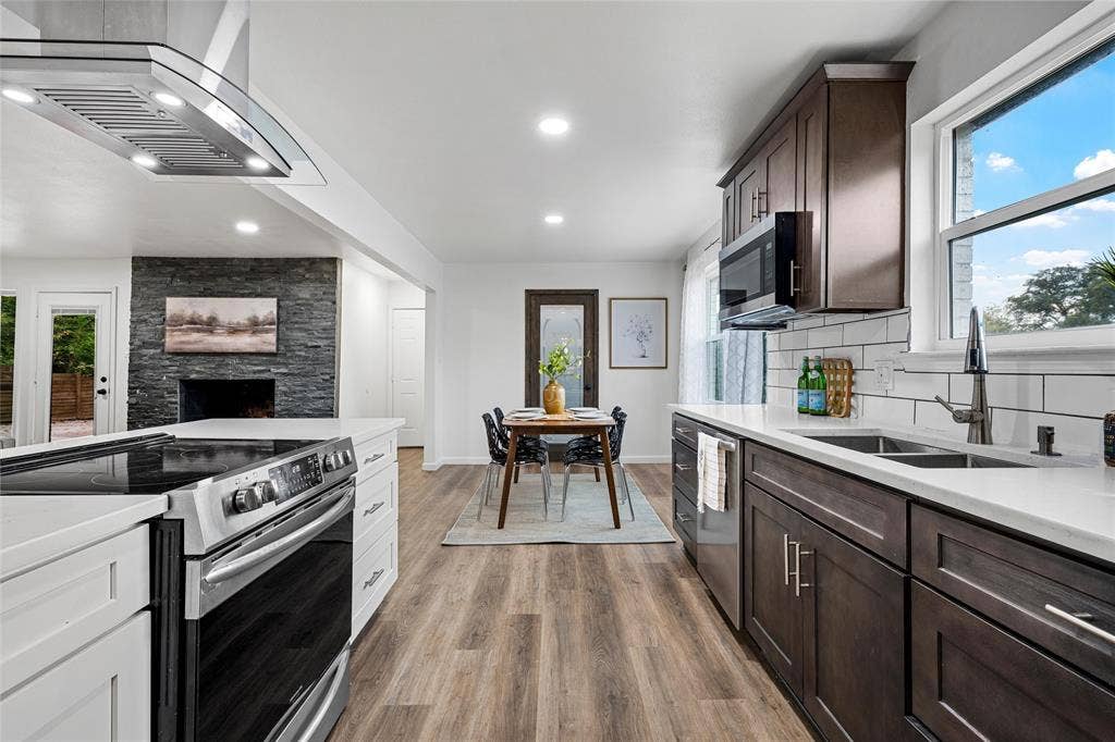 1132 Western Oaks Drive, Woodway, TX 76712 Bright kitchen featuring white countertops, stainless steel appliances, dark wood-finish cabinetry, and wood-finish flooring