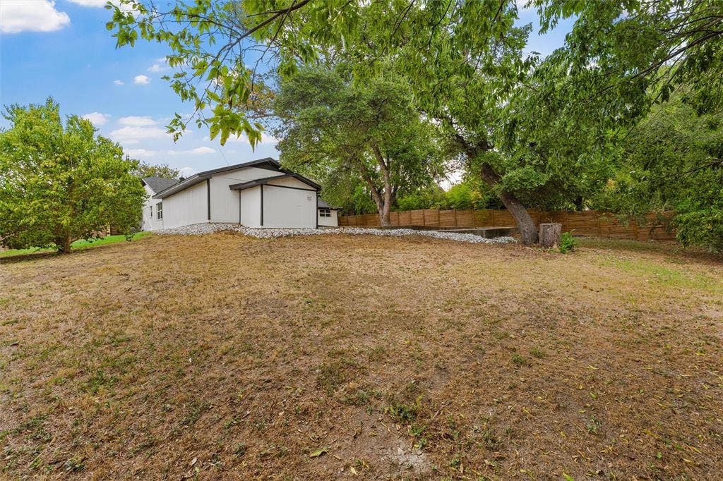 1132 Western Oaks Drive, Woodway, TX 76712 Expansive property featuring a contemporary-style home, mature trees, and a wooden fence