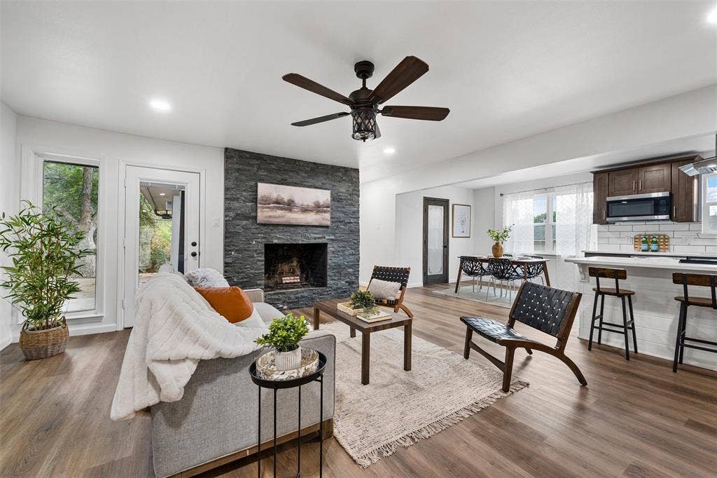 1132 Western Oaks Drive, Woodway, TX 76712 Wood-finish flooring throughout, a stone-faced fireplace, recessed lighting, and a ceiling fan