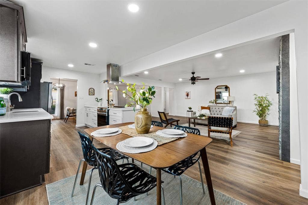 1132 Western Oaks Drive, Woodway, TX 76712 Open-concept living space featuring wood-finish flooring, recessed lighting, and a kitchen with a stainless steel range hood