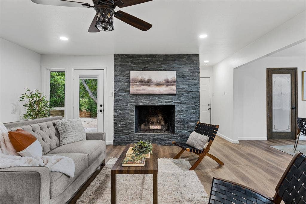 1132 Western Oaks Drive, Woodway, TX 76712 Stacked stone fireplace, wood-finish flooring, recessed lighting, ceiling fan, and exterior access