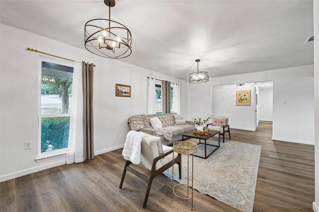 1132 Western Oaks Drive, Woodway, TX 76712 Wood-finish flooring throughout, bright white walls, two contemporary ceiling light fixtures, and a cased opening providing access to another area
