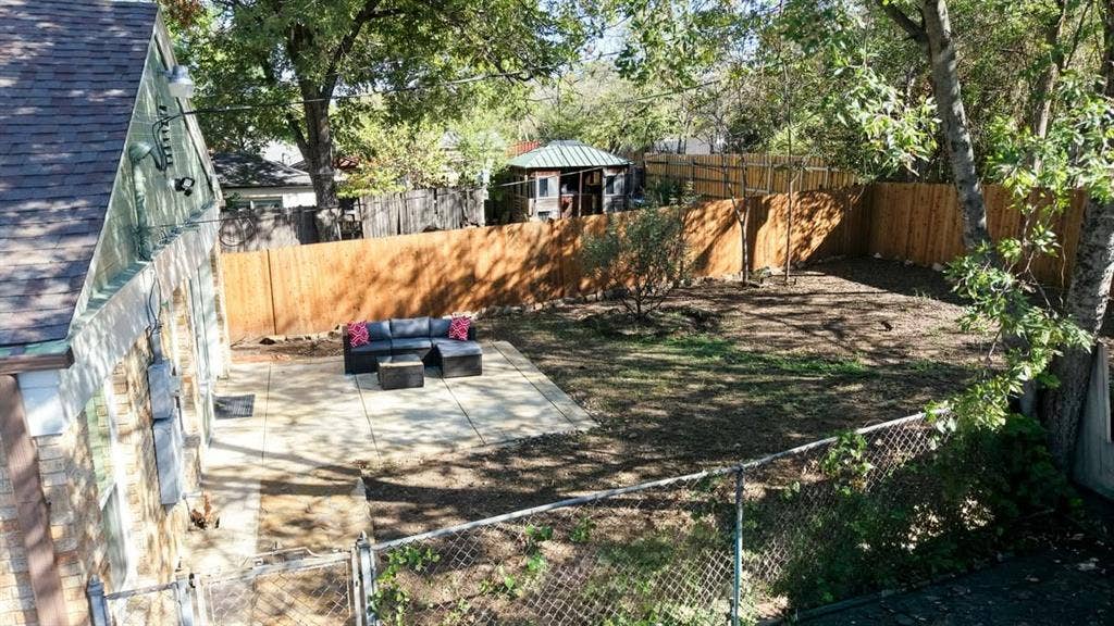 510 S Westmoreland Road, Dallas, TX 75211 Expansive backyard featuring a new privacy fence, mature trees, and a spacious patio area