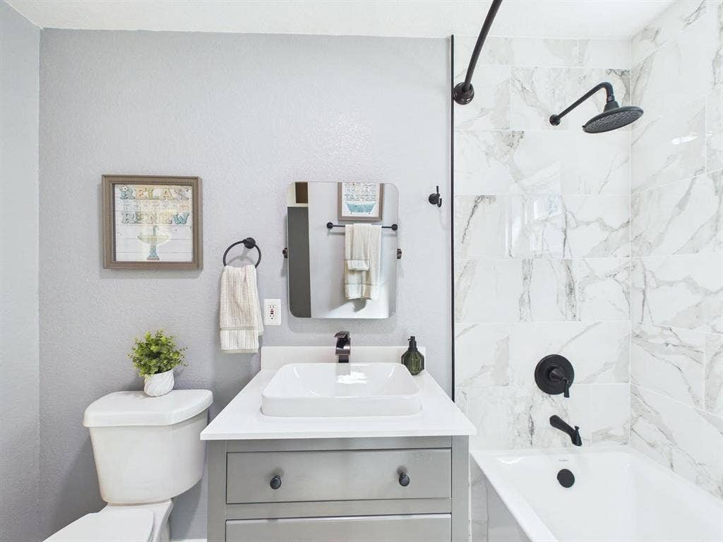 510 S Westmoreland Road, Dallas, TX 75211 Bathroom featuring a vanity with a rectangular basin, white countertop, and gray cabinetry