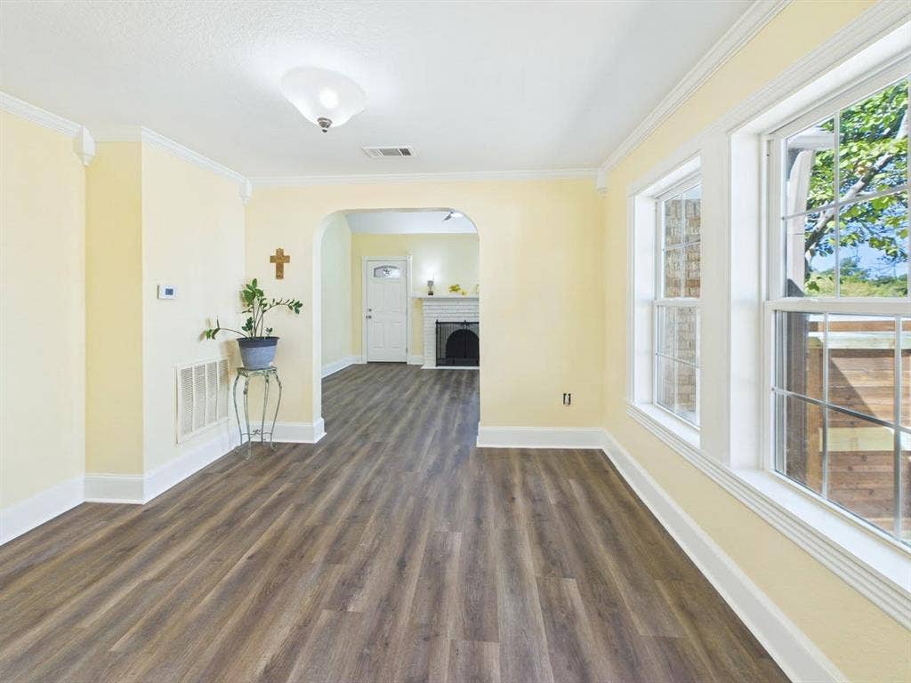 510 S Westmoreland Road, Dallas, TX 75211 Wood-finish flooring, white trim, crown molding, double-hung windows, and a ceiling-mounted light fixture