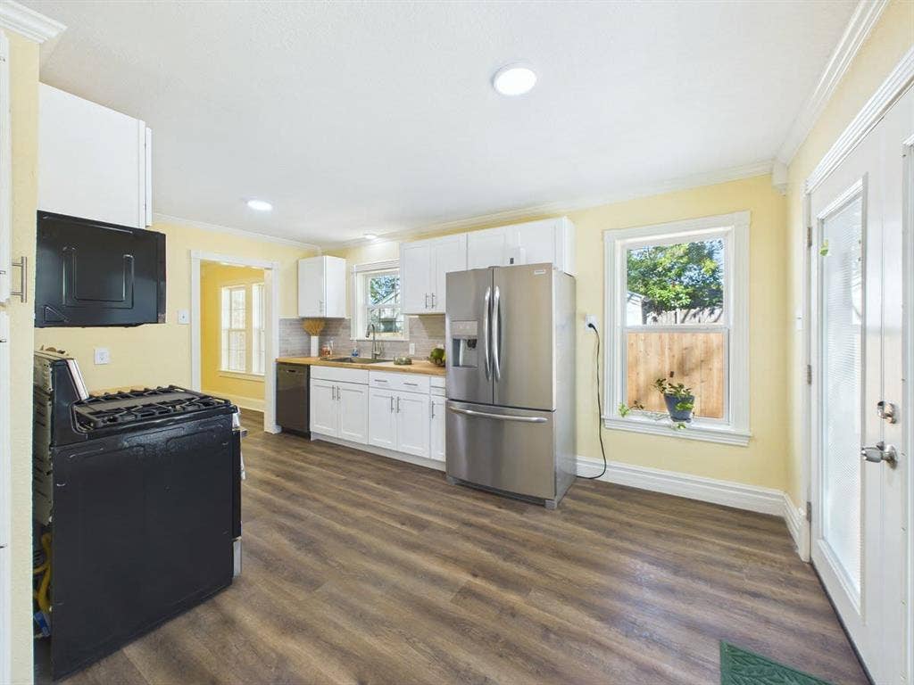 510 S Westmoreland Road, Dallas, TX 75211 Kitchen featuring wood-finish flooring, white cabinetry, recessed lighting, stainless steel refrigerator, and a built-in dishwasher
