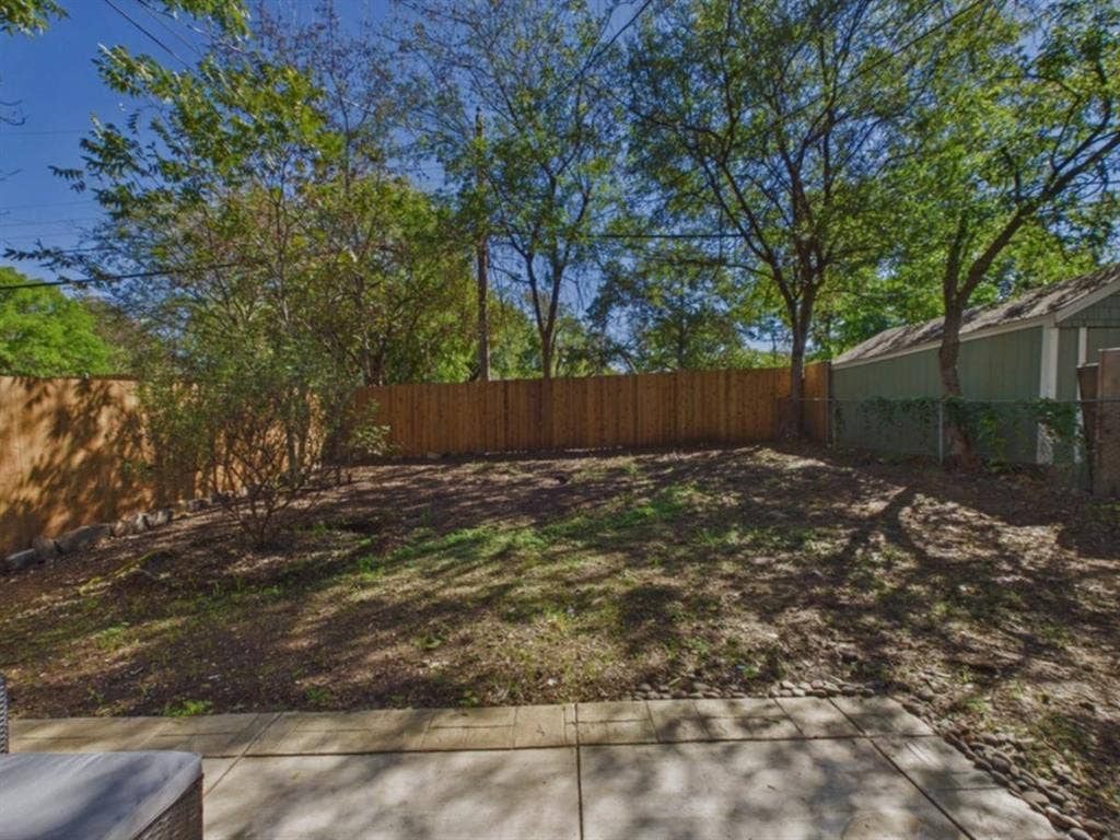 510 S Westmoreland Road, Dallas, TX 75211 Expansive outdoor space featuring a concrete patio, wood privacy fencing, and mature trees