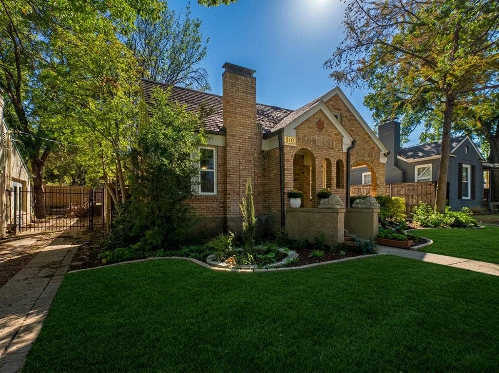 510 S Westmoreland Road, Dallas, TX 75211 Brick exterior with an arched entryway, gabled roofline, and a prominent brick chimney