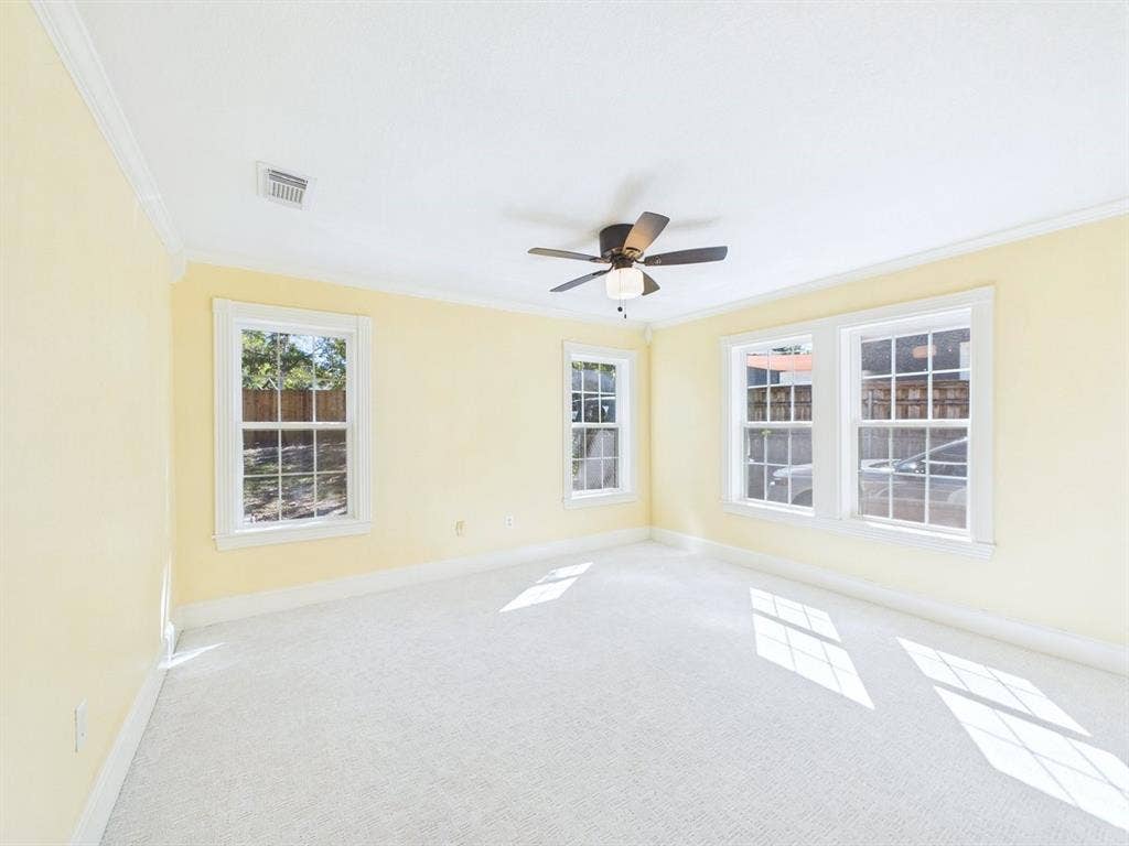 510 S Westmoreland Road, Dallas, TX 75211 Room with multiple double-hung windows, crown molding, and a ceiling fan with integrated lighting