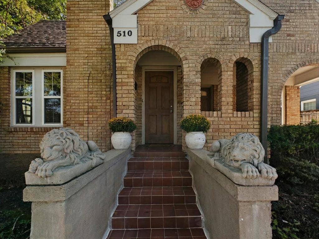 510 S Westmoreland Road, Dallas, TX 75211 Brick facade with arched entry, complementing brick archways, tiled steps, and decorative stone balustrades