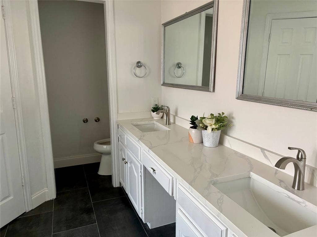 3713 San Juan Circle, Plano, TX 75023 Dual vanity with white cabinetry, integrated rectangular sinks, and a marble-finish countertop