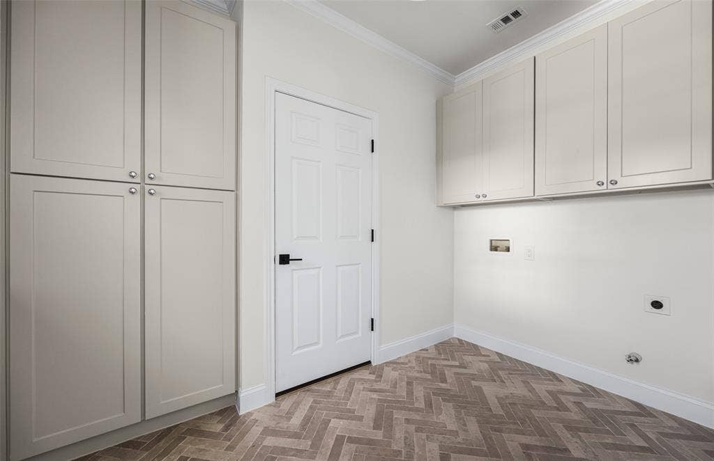 5901 Glen Heather Drive, Plano, TX 75093 Exceptionally spacious utility room doubles as a functional mudroom, with extensive floor-to-ceiling cabinetry, additional upper storage, washer and dryer connections, and distinctive herringbone-pattern tile flooring.