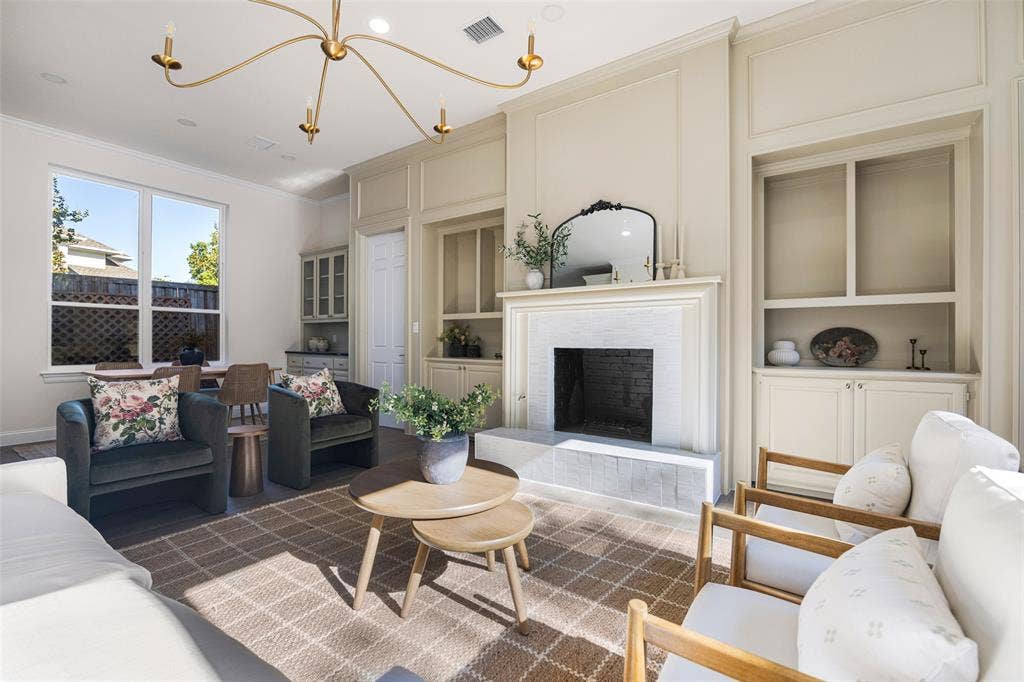 5901 Glen Heather Drive, Plano, TX 75093 Symmetrical built-ins, statement chandelier, a generous seating area, and backyard-facing windows all add the the inviting feel of the living space.