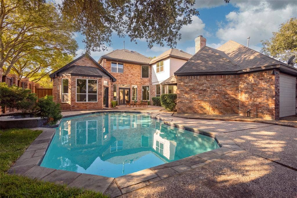 5901 Glen Heather Drive, Plano, TX 75093 Private backyard centered around an in-ground pool and spa, with generous surrounding deck space, mature landscaping, and the home's expansive rear elevation creating an inviting setting for outdoor entertaining