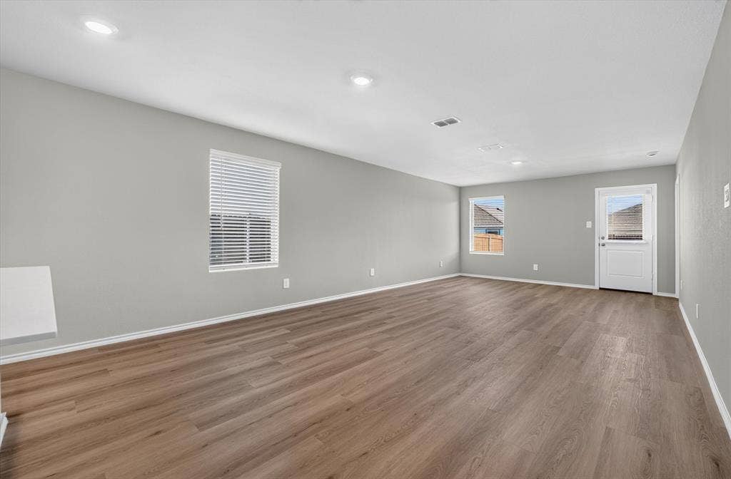 5413 Flannel Lane, Denton, TX 76249 Spacious room featuring wood-finish flooring, recessed lighting, and multiple windows with blinds