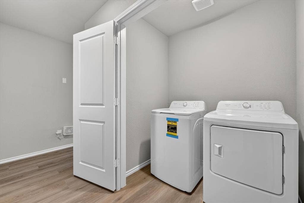 5413 Flannel Lane, Denton, TX 76249 Dedicated laundry area featuring a washer and dryer, light gray walls, and wood-finish flooring