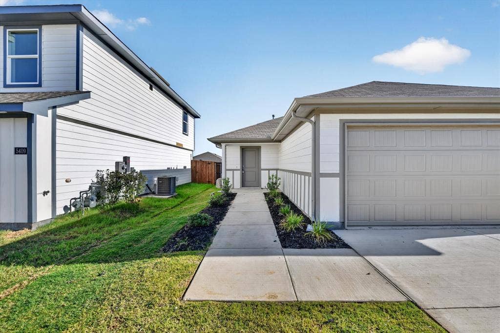5413 Flannel Lane, Denton, TX 76249 Contemporary exterior with white siding, gray trim, attached garage, concrete pathway, and landscaped planters