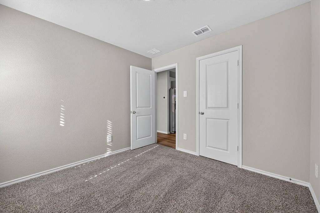 5413 Flannel Lane, Denton, TX 76249 Neutral wall paint, gray carpeting, white trim, and white paneled doors