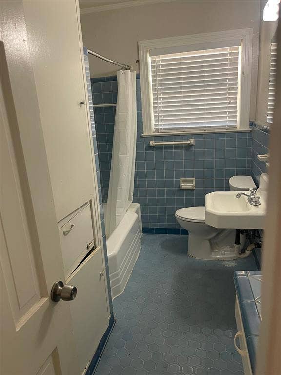 1527 Harbor Road, #1527, Dallas, TX 75216 Built-in linen cabinetry, window with blinds, subway-tiled bathtub/shower combination, pedestal sink, and blue hexagonal floor tiling