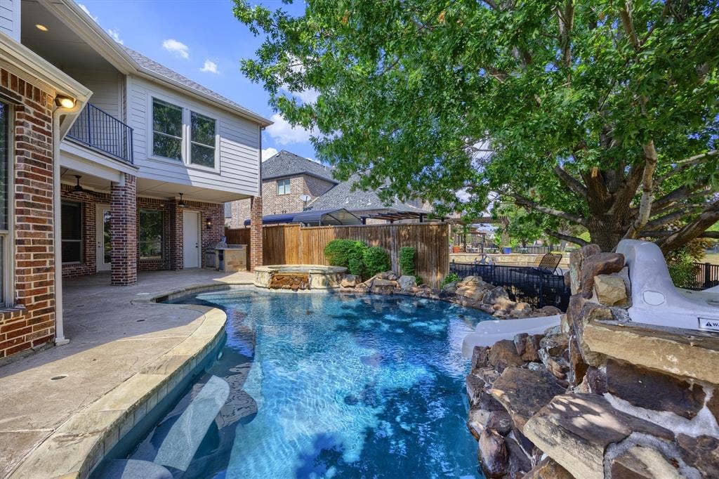 5960 Indigo Sky Drive, Frisco, TX 75036 Sparkling pool with slide and view of the greenbelt! Mature trees add privacy.