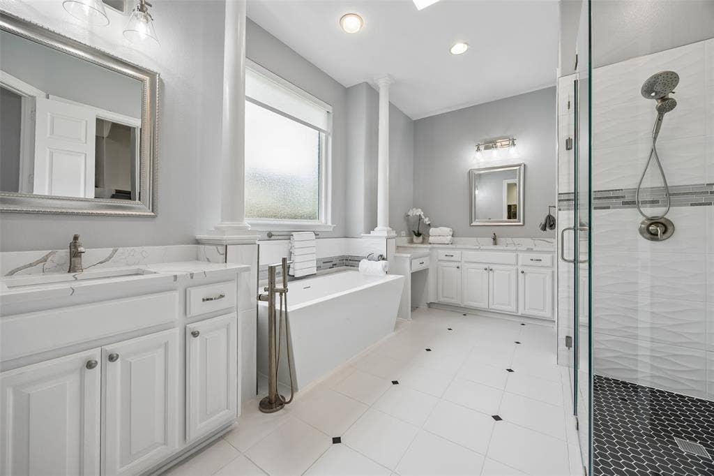1011 Three Rivers Drive, Prosper, TX 75078 Spa-inspired primary bath featuring a freestandingsoaking tub, oversized walk-in shower, dualvanities, and dual closets, including one with access to the utility room for everydayconvenience.