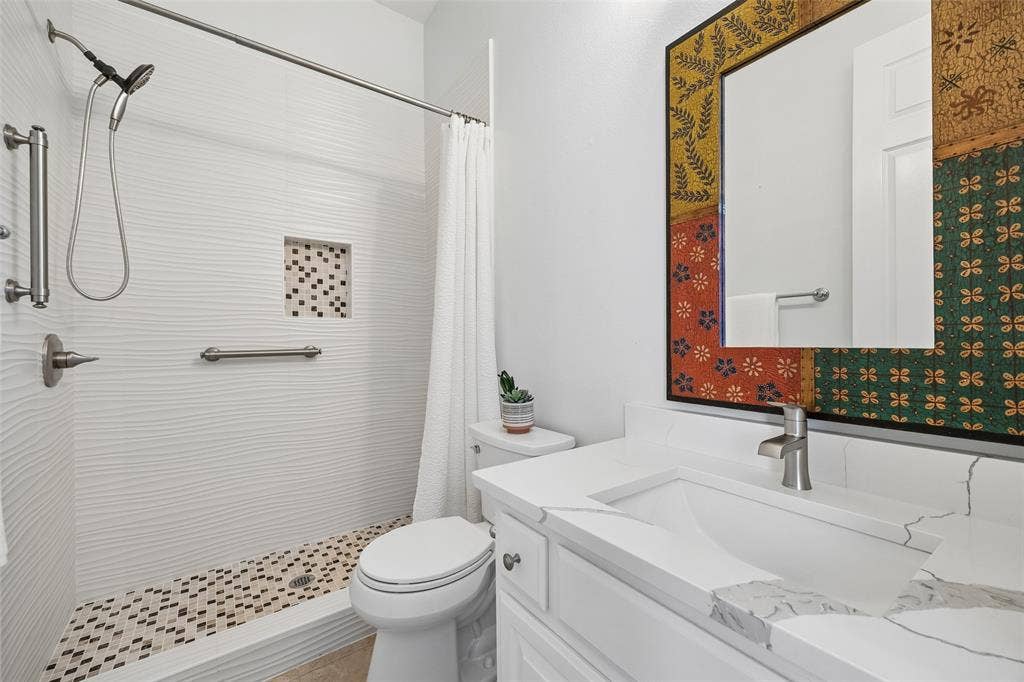 1011 Three Rivers Drive, Prosper, TX 75078 Updated downstairs guest bath featuring a spacious walk-in shower, quartz countertop, and stylish finishes, conveniently serving the private guestsuite.