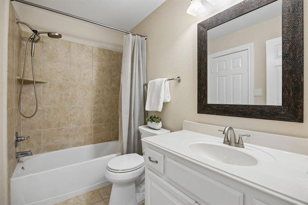 1011 Three Rivers Drive, Prosper, TX 75078 Well-appointed hall bath conveniently serving asecondary bedroom, media room, and game room,with neutral finishes and tiled shower surround.