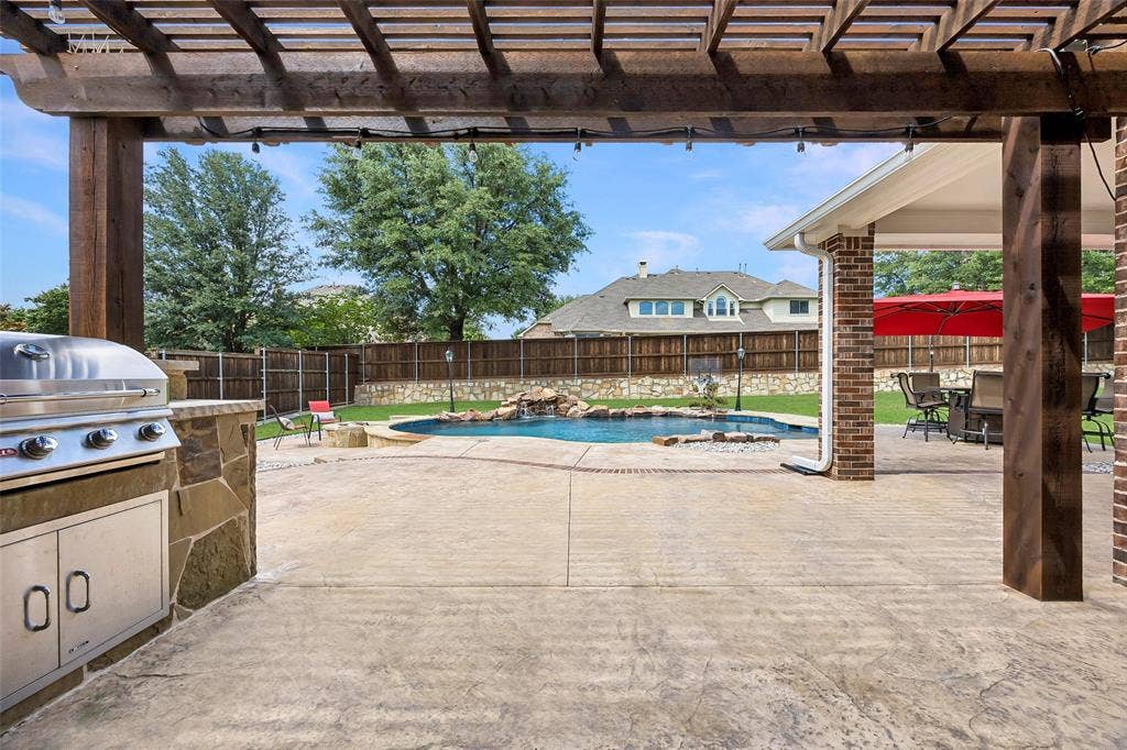 1011 Three Rivers Drive, Prosper, TX 75078 Resort-style backyard featuring a sparkling pool,pergola-covered patio with built-in grill, and multiple spaces for outdoor entertaining.