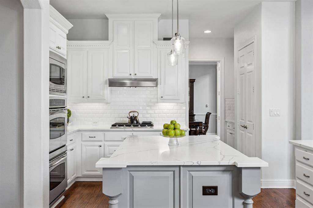 1011 Three Rivers Drive, Prosper, TX 75078 Bright, updated kitchen featuring quartz countertops, crisp white cabinetry, stainless steelappliances, and a spacious island ideal forgathering.