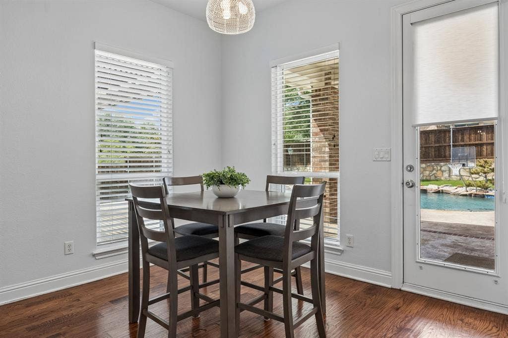 1011 Three Rivers Drive, Prosper, TX 75078 Bright breakfast area with wood floors and pool views, offering easy indoor-outdoor access foreveryday living and entertaining.
