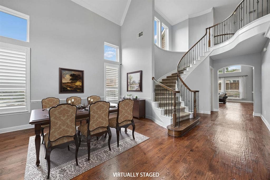1011 Three Rivers Drive, Prosper, TX 75078 Dining area with soaring ceilings, rich wood floors,and a sweeping staircase that creates a stunning first impression.