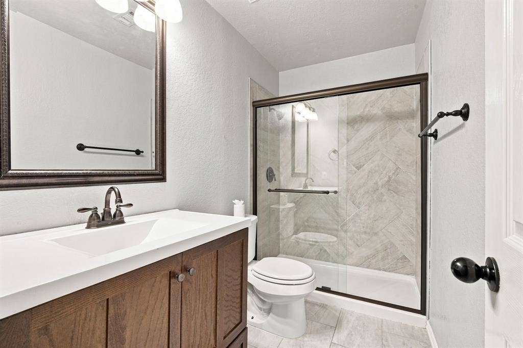 7030 Pecan Creek Circle, Midlothian, TX 76065 Charming bath featuring a vanity with an integrated sink, a warm bronze-finish faucet, and a coordinating mirror.