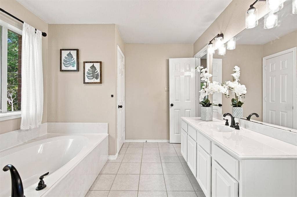 7030 Pecan Creek Circle, Midlothian, TX 76065 Elegant vanity with undermount sink, matte black faucets, and a large mirror for a spa-like feel.